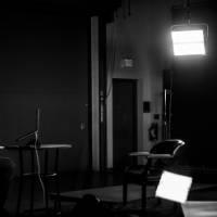 man sitting in studio, with studio lights on, giving a virtual presentation while seated